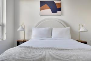 une chambre avec un lit blanc et deux lampes dans l'établissement Blueground New Tacoma balcony nr Museum SEA-957, à Tacoma