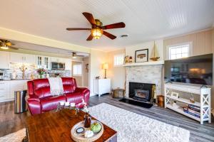 a living room with a red couch and a fireplace at Wilson Waterfront Getaway Near Hikes and Wineries! in Wilson
