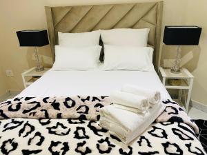 een slaapkamer met een wit bed met handdoeken erop bij Tranquil Retreat in Durban