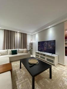 ein Wohnzimmer mit Couch und Flachbildfernseher in der Unterkunft resident faouzi Tamara harhora plage in El Harhoura