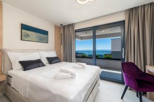 a bedroom with a large bed and a large window at Luxury Villa Helena, with heated pool in Makarska