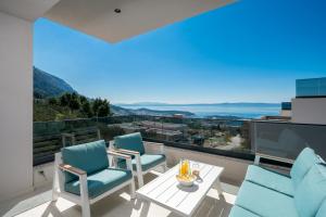 a balcony with chairs and a table and a view of the ocean at Luxury Villa Helena, with heated pool in Makarska