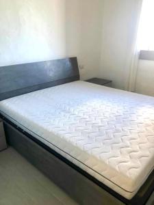 1 cama en un dormitorio con colchón blanco en Appartamento Elysie, en Puntaldia