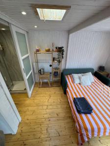 Un dormitorio con una cama en la esquina de una habitación. en Lodge near Bath for relaxing getaway with Hot tub, en Chittoe 5 fotos más