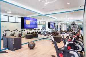 ein Fitnessstudio mit vielen Laufbändern und Heimtrainern in der Unterkunft Blueground East Industrial pool nr Central Park SFO-2045 in Warm Springs District