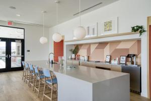 eine Küche mit einer großen Theke und Stühlen drumherum in der Unterkunft Blueground East Industrial pool nr Central Park SFO-2045 in Warm Springs District