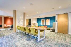 einen Konferenzraum mit einem Tisch und gelben Stühlen in der Unterkunft Blueground East Industrial pool nr Central Park SFO-2045 in Warm Springs District + 42 Fotos