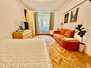 a bedroom with a bed and a couch and a tv at City-Centre appartment in Piešťany