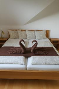 a bed with two swans decorations on it at Villa Slupečná in Lipno nad Vltavou