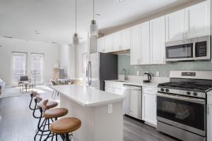 eine Küche mit weißen Schränken und einem Herd mit Backofen in der Unterkunft Blueground Bethesda fitness center nr Cabin John Park WDC-666 in Bethesda