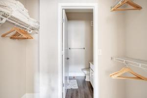 ein weißes Bad mit einem WC und einem Schrank in der Unterkunft Blueground Bethesda fitness center nr Cabin John Park WDC-666 in Bethesda + 32 Fotos