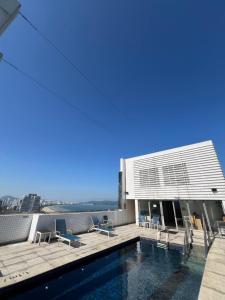 a building with a swimming pool on top of it at Flats na praia com AC, piscina, sauna e academia! in Santos