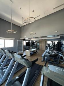 a gym with treadmills and elliptical machines at Flats na praia com AC, piscina, sauna e academia! in Santos
