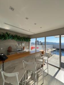 a kitchen and dining room with a view of the ocean at Flats na praia com AC, piscina, sauna e academia! in Santos