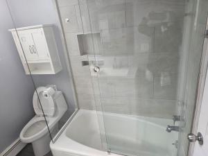 a bathroom with a toilet and a glass shower at Cozy Getaway in Kearny