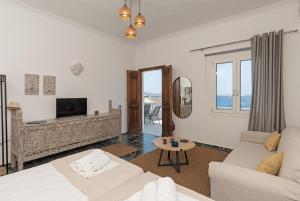 a living room with a couch and a tv at Vivere Luxury Suites in Pera Gyalos