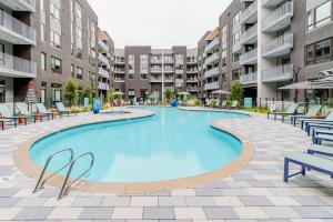 ein großer Pool mit Stühlen und Gebäuden in der Unterkunft Blueground East Industrial pool nr Central Park SFO-2080 in Warm Springs District