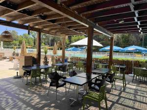a patio with tables and chairs and umbrellas at Appartement avec vue sur la mer in Six-Fours-les-Plages