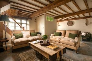 a living room with two couches and a coffee table at Homestead - Cosy Cotswolds Cottage with Hot Tub in South Cerney