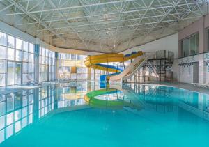 a swimming pool with a water slide in a building at Dora Thermal Tatil Köyü & Spa in İhsaniye