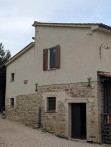 an old stone building with two windows and a door at Agriboutique L'Uliveto Magico in Cannara