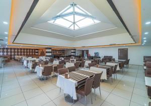 a dining room with tables and chairs and a large window at Dora Thermal Tatil Köyü & Spa in İhsaniye