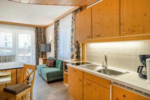 a kitchen with a sink and a living room at Studio Appartement Haus Voglreiter in Kaprun