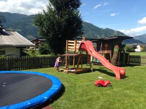 a little girl playing on a playground with a slide at Studio Appartement Haus Voglreiter in Kaprun