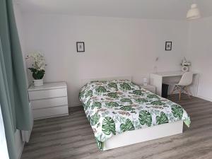 a white bedroom with a bed and a desk at Maison proche Fatima batalha in Reguengo do Fetal