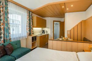 a kitchen with a bed and a couch in a room at Studio Appartement Haus Voglreiter in Kaprun +28 photos