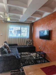 a living room with a couch and a flat screen tv at BnB in Mombasa +7 photos