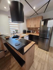 a kitchen with a stainless steel refrigerator and wooden cabinets at Rose in Bielawa