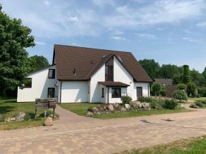 ein weißes Haus mit braunem Dach in der Unterkunft Ferienhaus HirschRudel - Ferienwohnung 4 in Lodmannshagen
