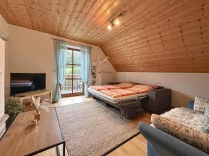 a bedroom with a bed and a couch and a tv at Weiherblasch in Dietersdorf