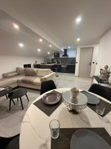 a living room with a couch and a table and chairs at Cosy Room Trèbes in Trèbes