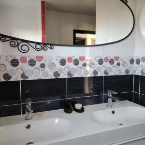 a bathroom with a sink and a mirror at Au Chat l'Heureux in Mackenheim