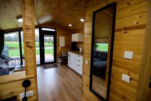 a kitchen and living room in a tiny house at Privatus romantiškas namelis dviems prie vandens Šilalės rajone in Dirkintai