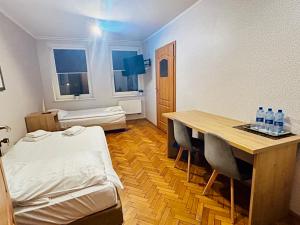 ein Zimmer mit einem Bett und einem Tisch mit Stühlen in der Unterkunft Stary Młyn in Żory