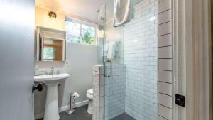 een witte badkamer met een wastafel en een douche bij The Shipwright's Bungalow in Saint Simons Island +17 foto's