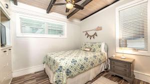 een slaapkamer met een bed en een plafondventilator bij The Shipwright's Bungalow in Saint Simons Island