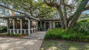 een huis met een veranda en een boom bij The Shipwright's Bungalow in Saint Simons Island