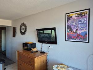 a living room with a tv on a wall at Studio LE CORBIER in Villarembert