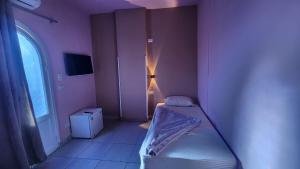 a small room with a bed and a window at Shapon Hotel - Hurghada in Hurghada