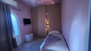 a small bedroom with a bed and a window at Shapon Hotel - Hurghada in Hurghada +12 photos