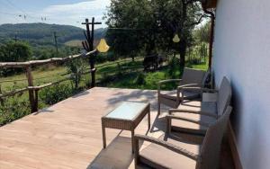 two chairs and a table on a wooden deck at Chata Chotár Nová Baňa in Veľká Lehota