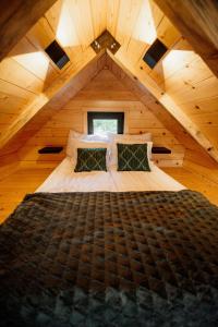 ノヴァ・ヴァロシュにあるKuća na drvetu - Zlatar Hill - Treehouseの屋根付きの木造の部屋にある大きなベッド