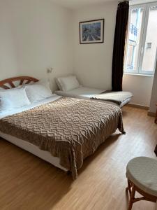 a bedroom with two beds and a window at Hotel Du Rocher in Le Caylar