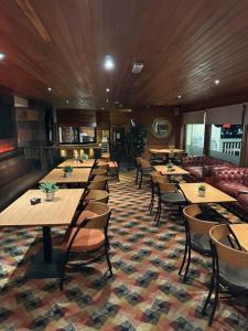 a restaurant with tables and chairs in a room at west park hotel PVT ltd in Clydebank