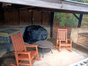 eine Terrasse mit 2 Stühlen, einem Tisch und einem Zelt in der Unterkunft Cozy Cabin for Two by the Lake for a Peaceful Escape in Opelika, Alabama in Opelika