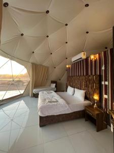 um quarto com uma cama grande em uma barraca em Desert Pearl Luxury Camp em Wadi Rum